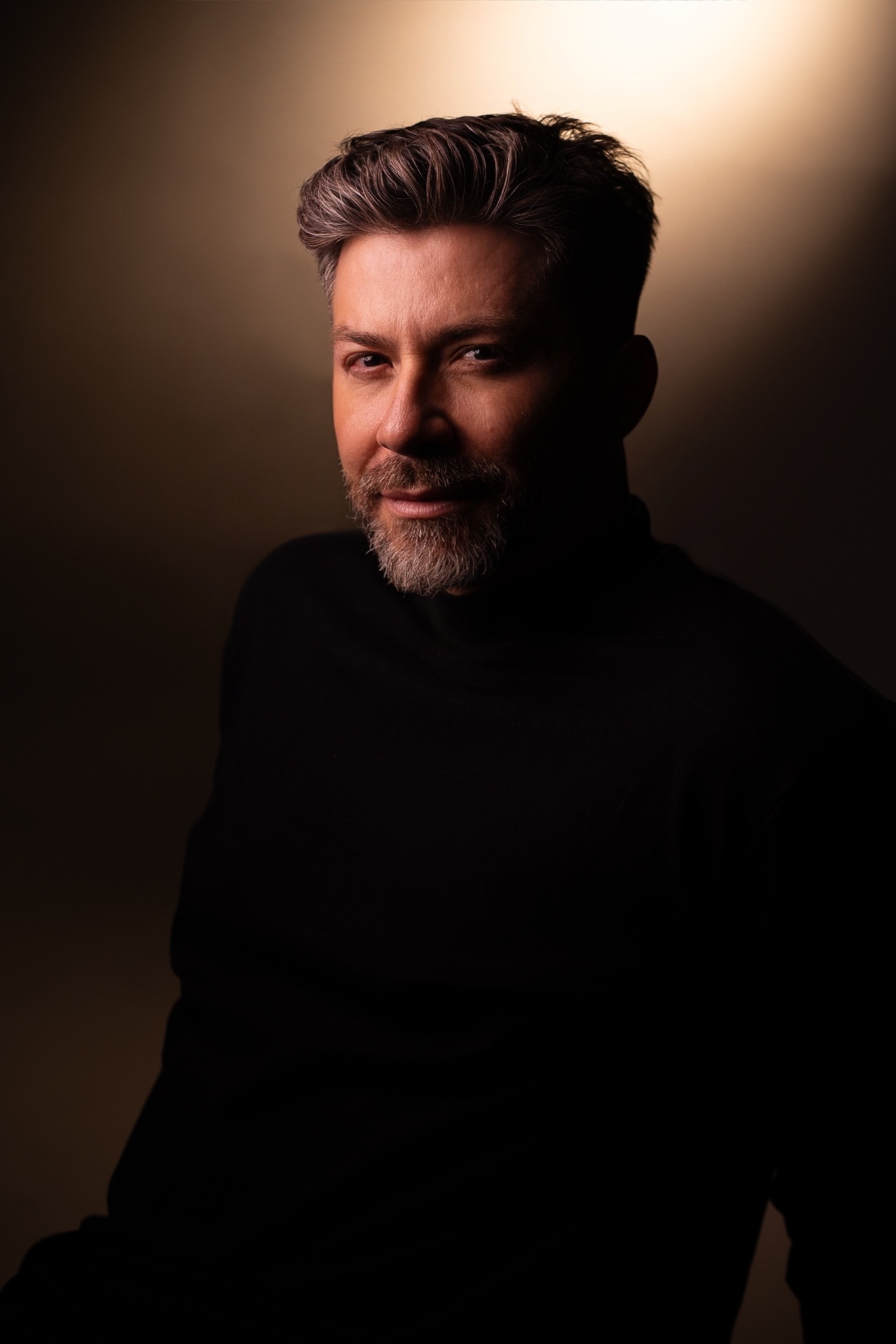 Retrato editorial de John Castaño sob luz quente